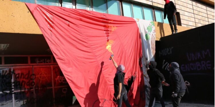 Encapuchados vandalizan UNAM y queman bandera de México